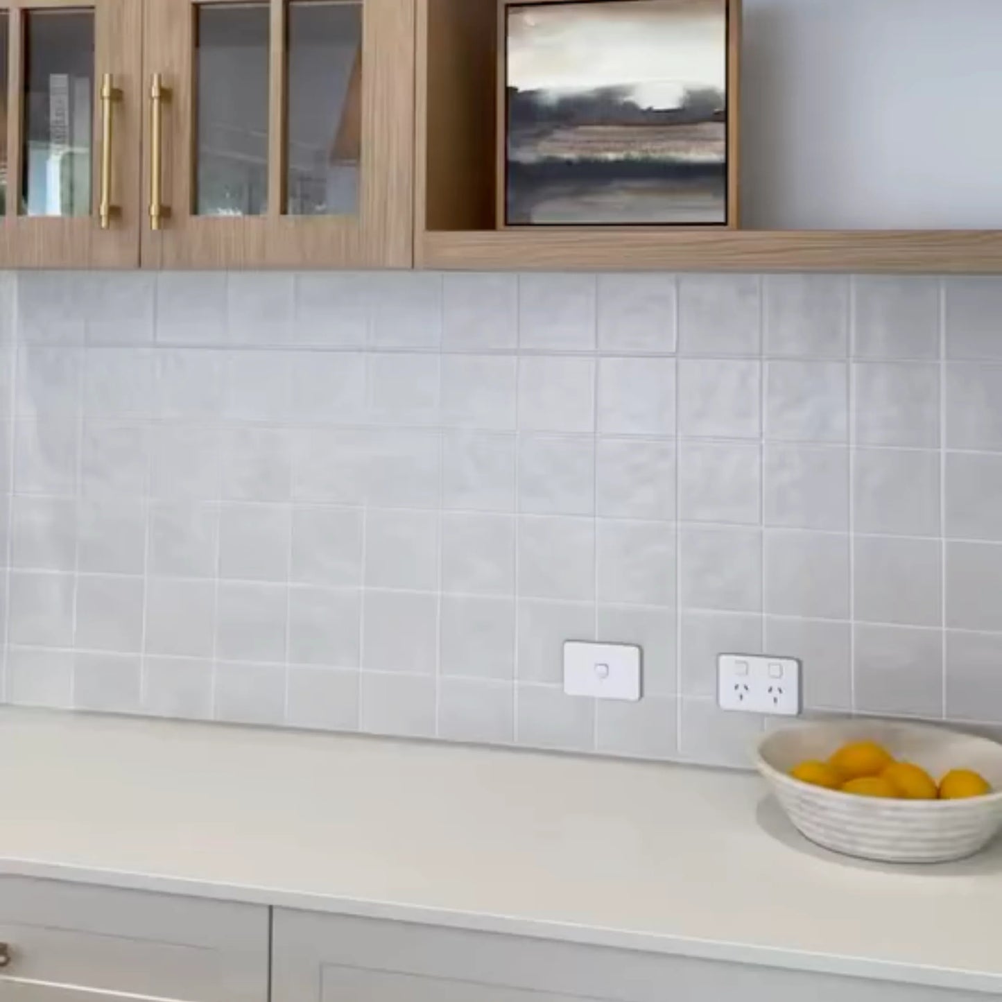 Casablanca White Matte 120x120mm tiles installed as a kitchen splashback behind timber cabinetry with gold handles and a white stone benchtop.