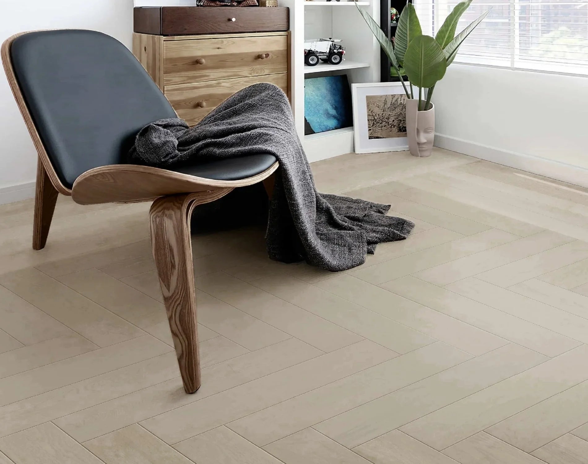 Casper White iDesign Herringbone Flooring 15/3mm installed in a modern bedroom with a sculptural wooden lounge chair, timber dresser, and indoor plant.