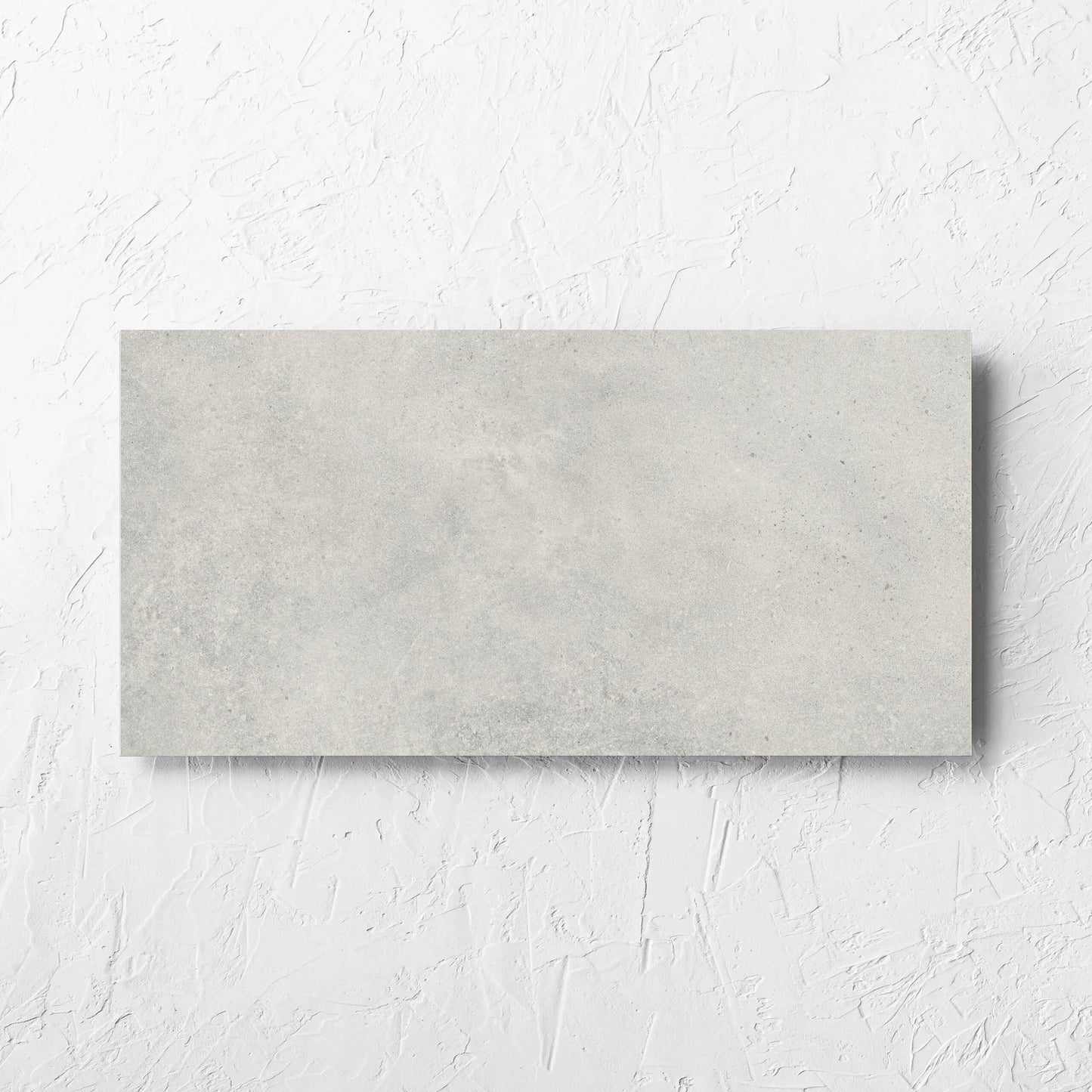 Cement Dark Grey Matt 300x600mm tile laid flat on a white rendered wall, showing the matt surface