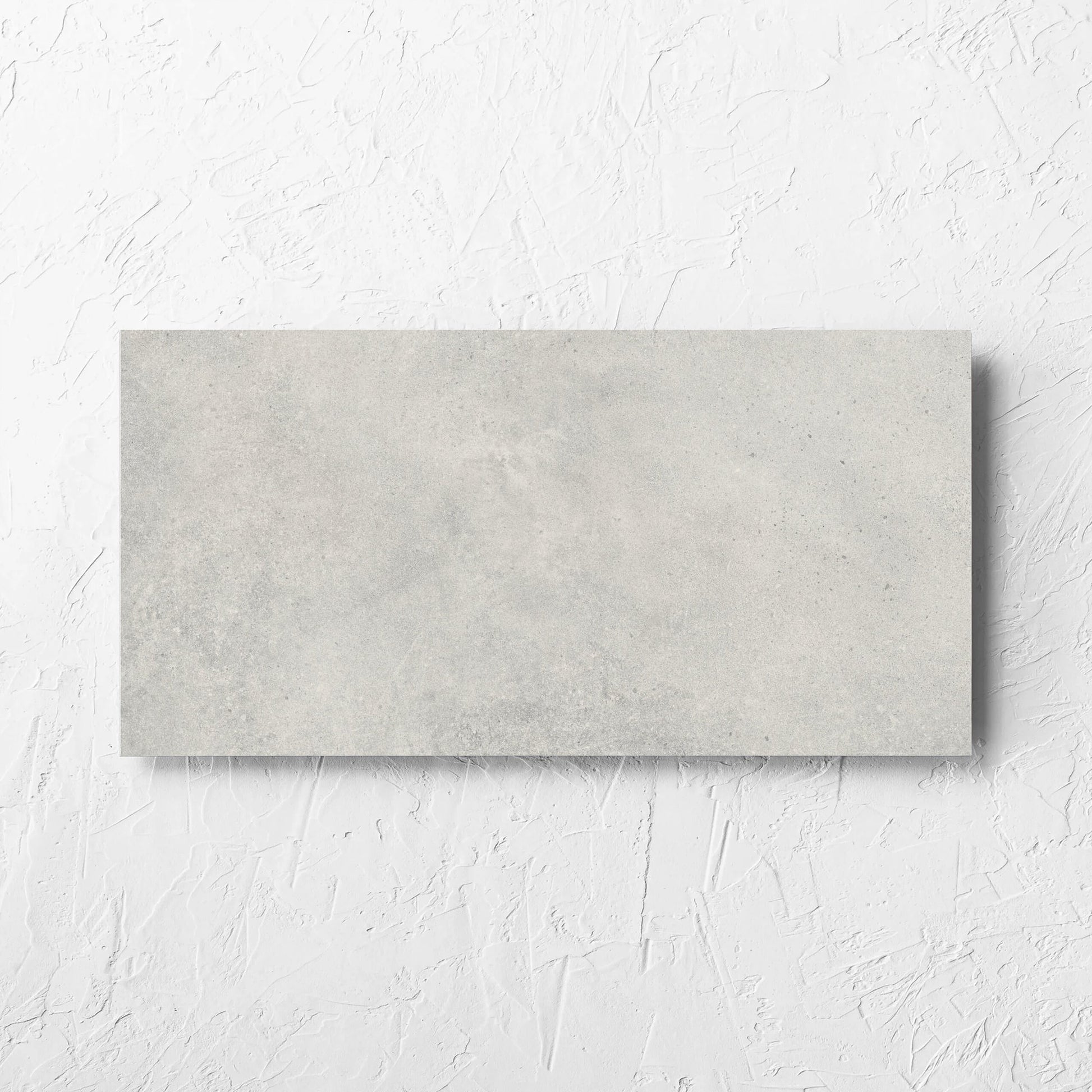 Cement Dark Grey Matt 300x600mm tile laid flat on a white rendered wall, showing the matt surface