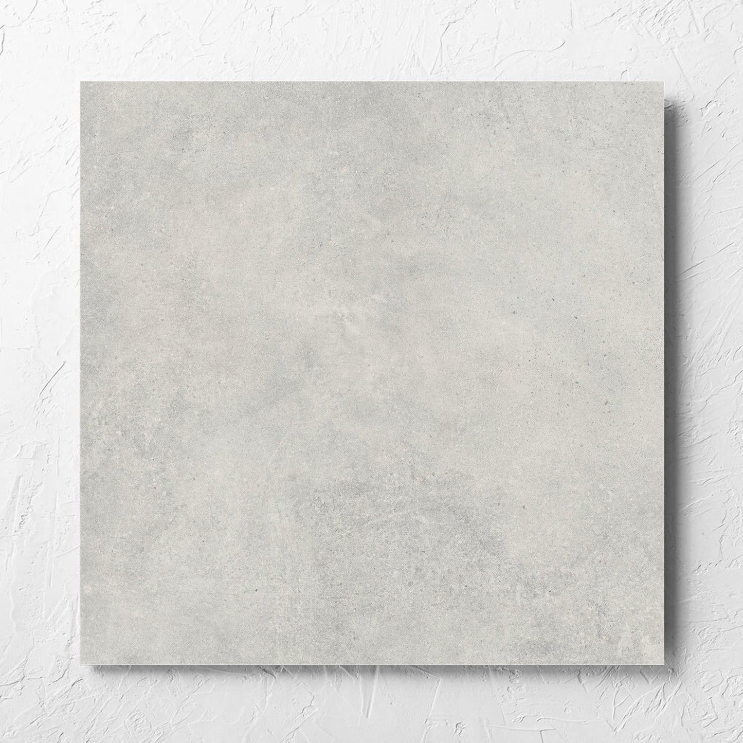 Cement Dark Grey Matt 600x600mm tile laid flat on a white rendered wall, showing the matt surface