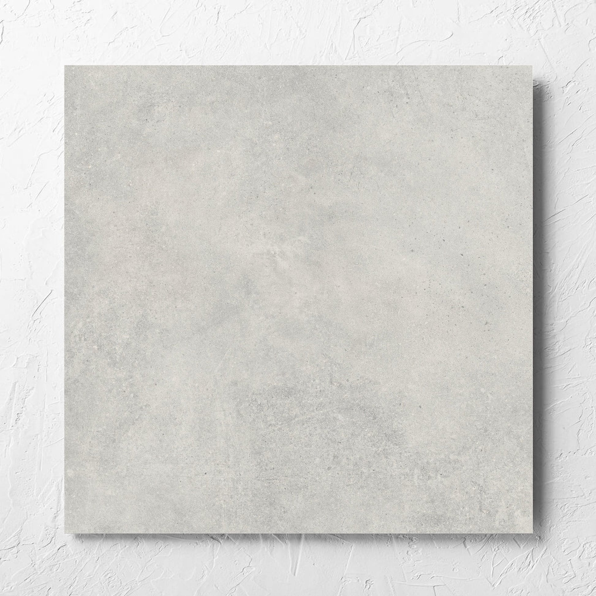 Cement Dark Grey Matt 600x600mm tile laid flat on a white rendered wall, showing the matt surface