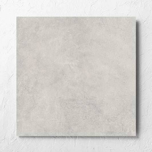 Cement Dark Grey Matt 600x600mm tile laid flat on a white rendered wall, showing the matt surface