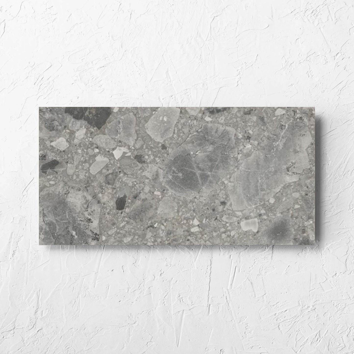 Ceppo Grey InOut 300x600mm tile laid flat on a white rendered wall, showing the tile surface
