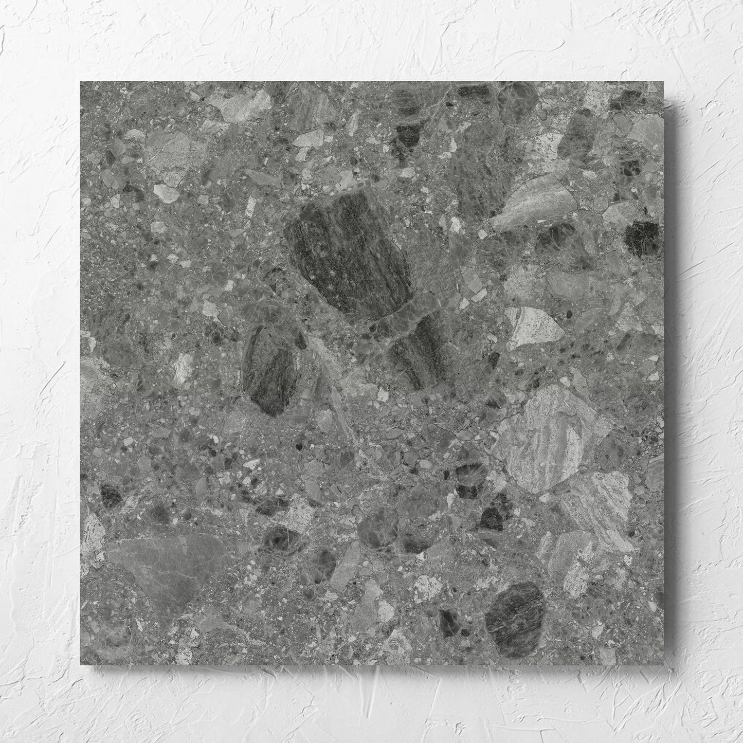 Ceppo Grey InOut 600x600mm tile laid flat on a white rendered wall, showing the tile surface