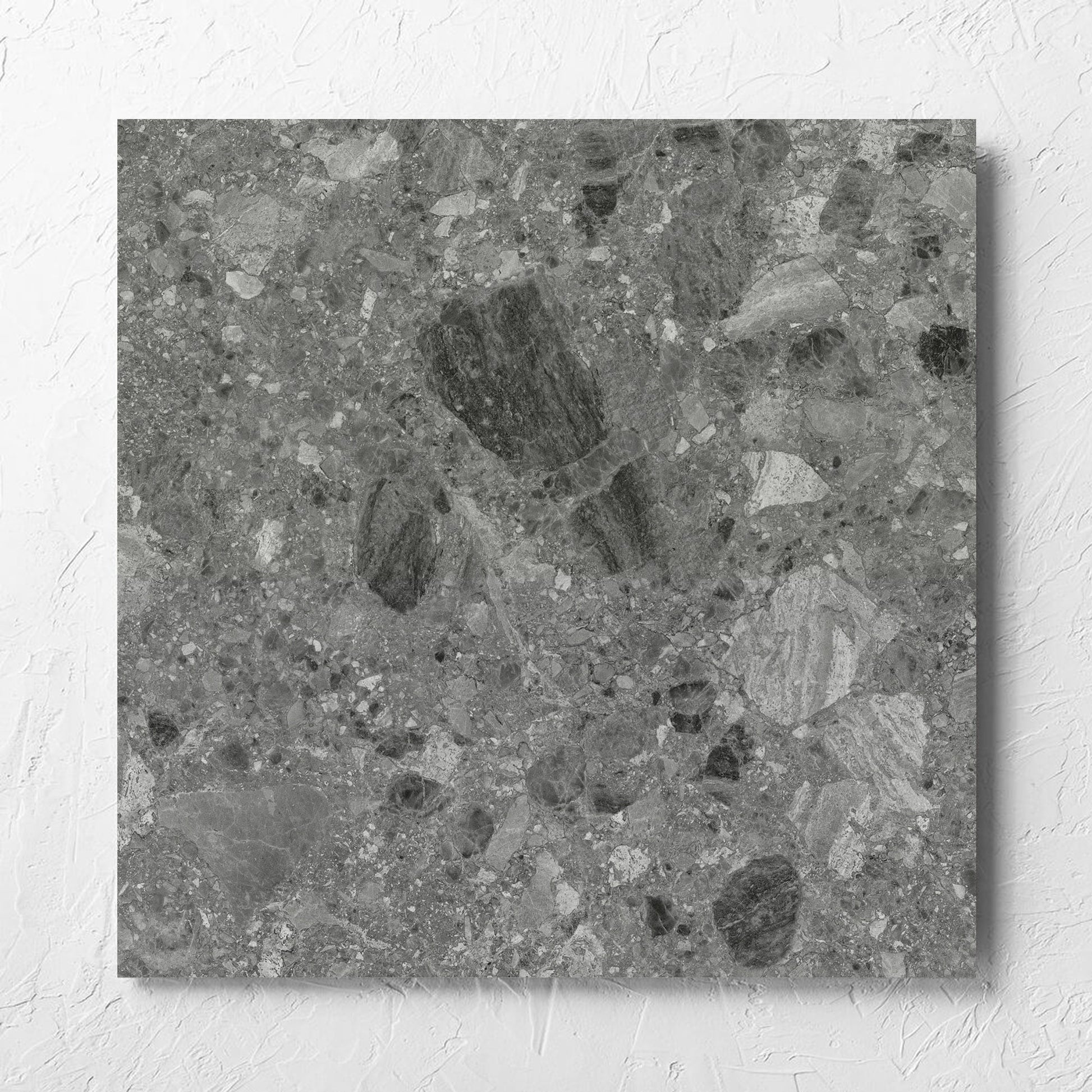 Ceppo Grey InOut 600x600mm tile laid flat on a white rendered wall, showing the tile surface