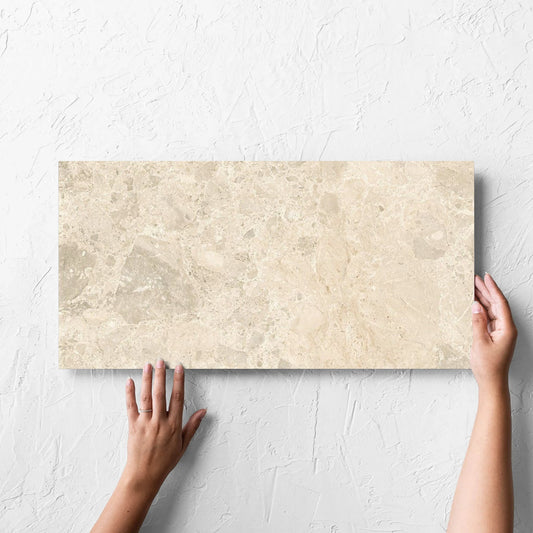 Hand holding a single Ceppo Light Beige InOut 300x600mm tile against a white rendered wall, showing the tile surface