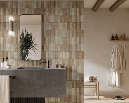 Chroma Caramel Matt 52x160mm tiles covering a full bathroom feature wall behind a concrete double vanity with black fixtures and round mirror.