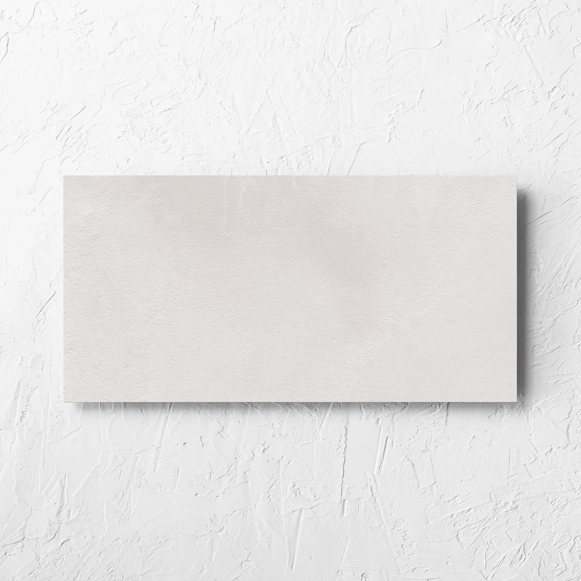 Clay Bari White 300x600mm tile laid flat on a white rendered wall, showing the matt surface