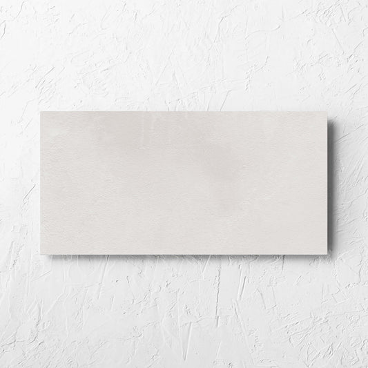 Clay Bari White 300x600mm tile laid flat on a white rendered wall, showing the matt surface
