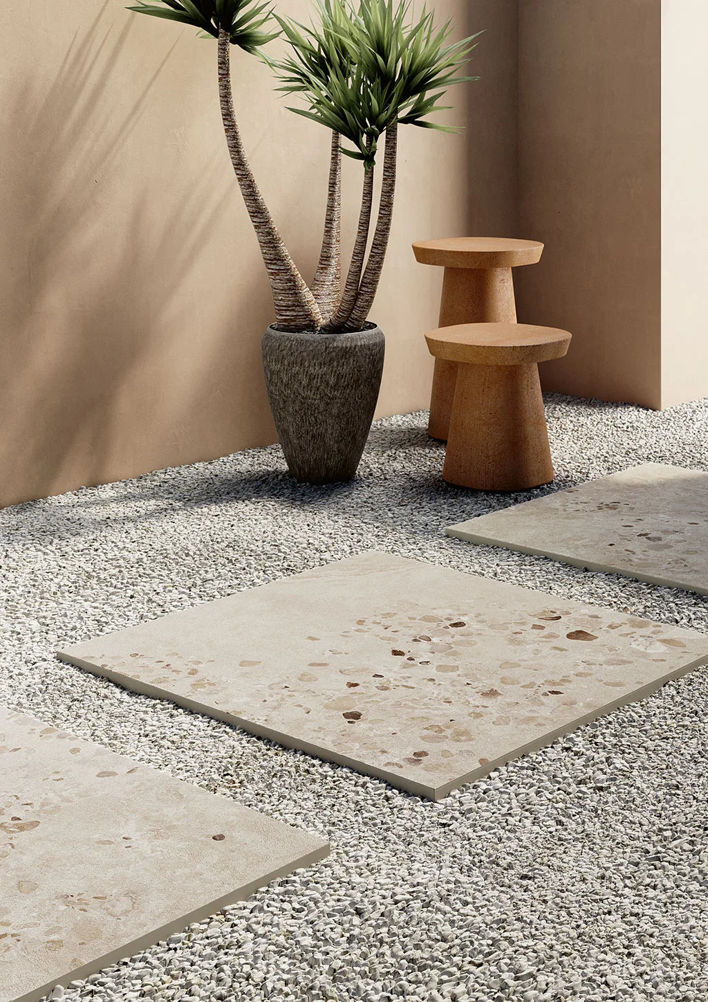 Cocci Sic. Bianco External 900x900mm porcelain pavers laid as stepping stones through a gravel garden courtyard with a potted palm and terracotta stools.