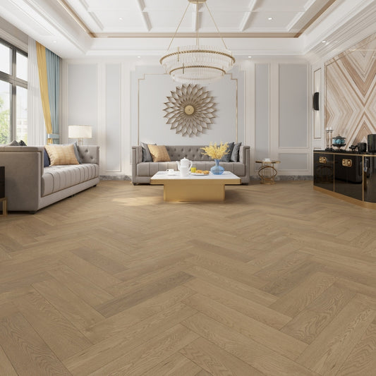 Coral Sand iDesign Herringbone Flooring 15/3mm installed in a luxurious living room featuring a crystal chandelier, tufted grey sofas, and gold accents.