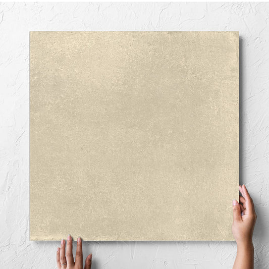 Hand holding a single Cotto Siena Matt 600x600mm tile against a white rendered wall, showing the matt surface