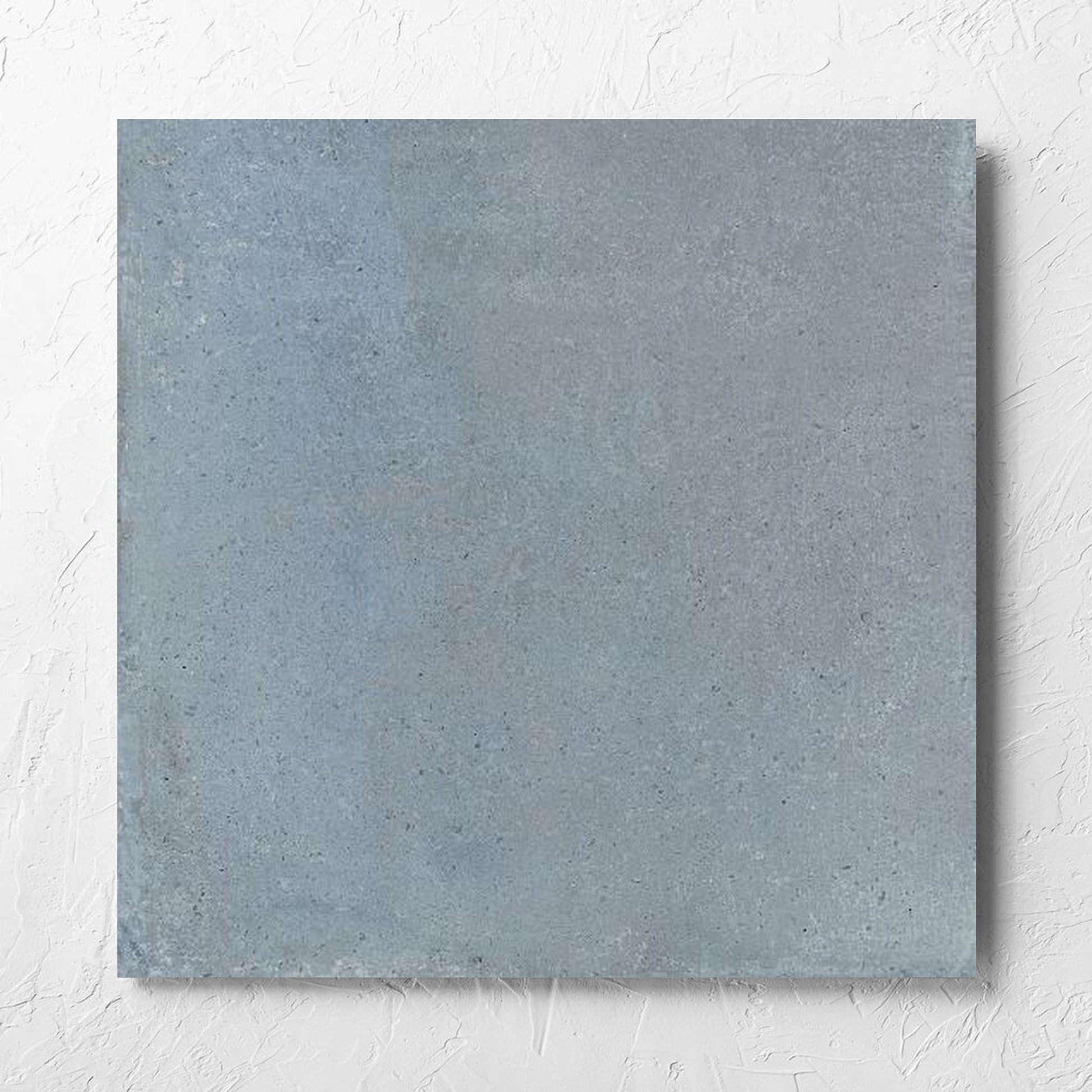 Cotto Sky Matt 600x600mm tile laid flat on a white rendered wall, showing the matt surface