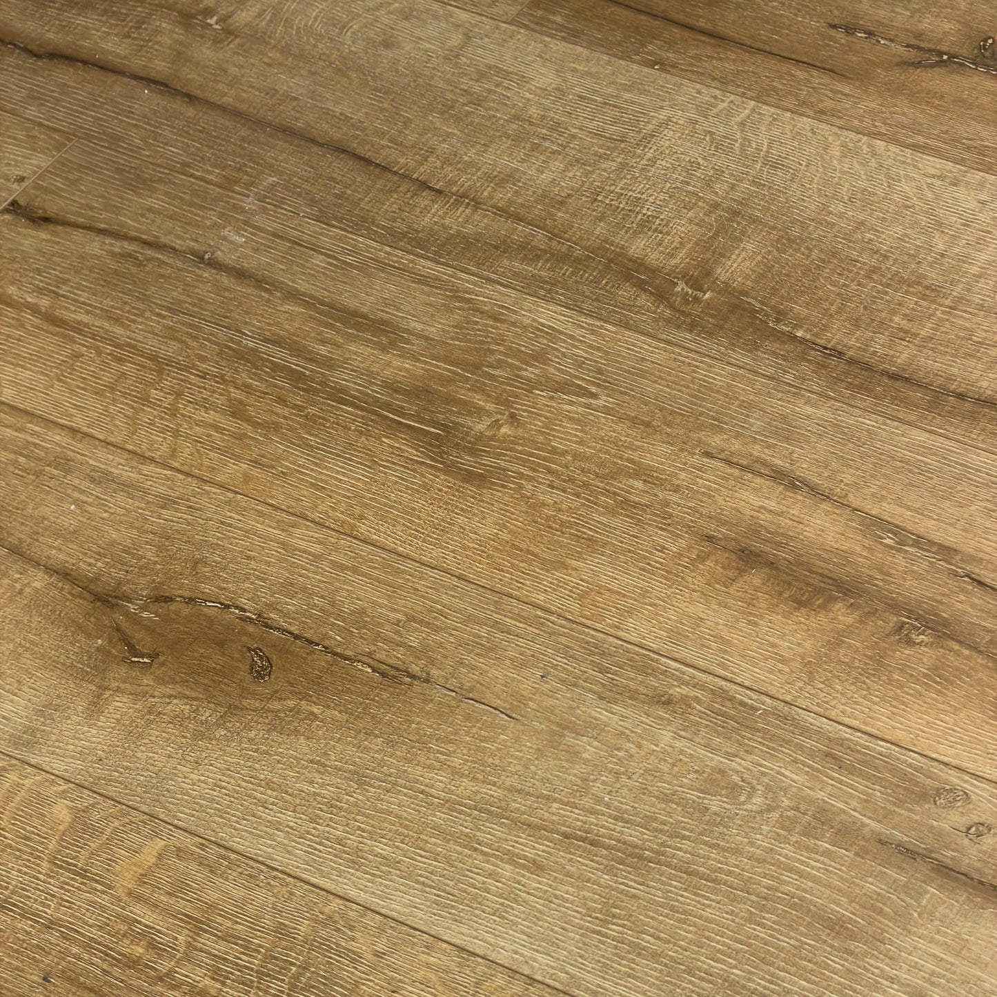 Close-up texture shot of Country Oak Urban Laminate 12mm Flooring 12mm showing warm brown wood grain, natural knots, and fine surface detail.