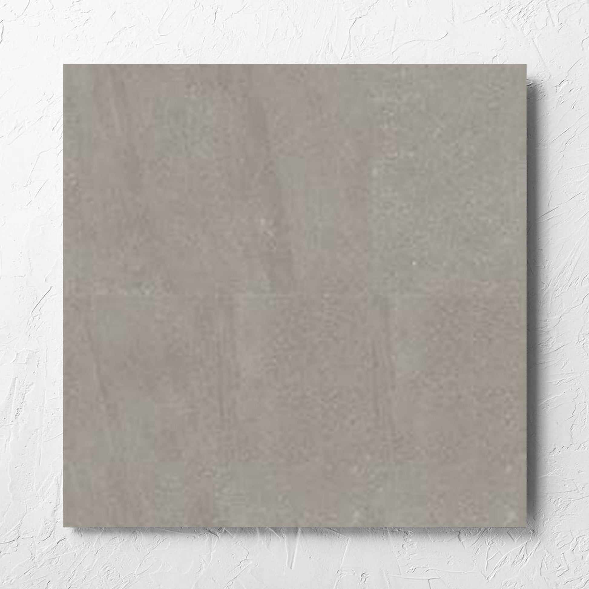 Crystal Quartz Greige Matt Rectified 600x600mm tile laid flat on a white rendered wall, showing the tile surface