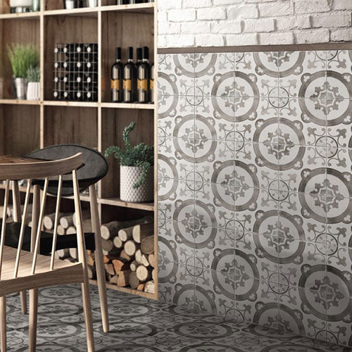 Da Vinci Florentine Matt 200x200mm grey patterned tiles installed on a wall and floor in a rustic wine bar setting with wooden shelving and bistro chair.