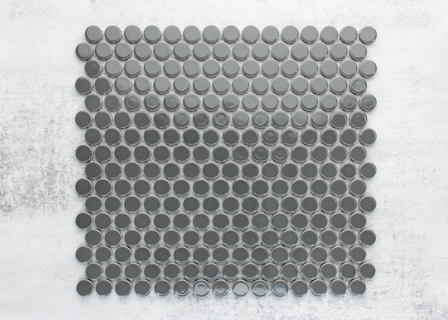 A flat lay sample sheet of Dark Grey Gloss Diameter Glazed Porcelain Penny Round 19mm tiles showing glossy circular mosaic pieces arranged in a grid pattern.