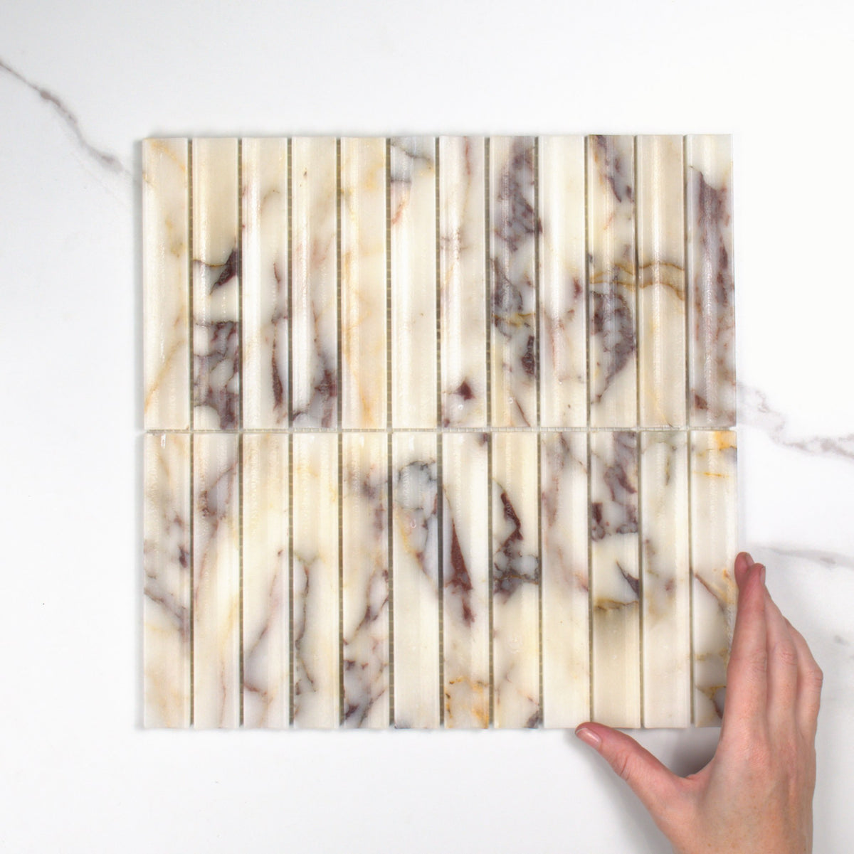 Elementa Calacatta Viola Concave Mosaic 23x148mm top view, hand for scale