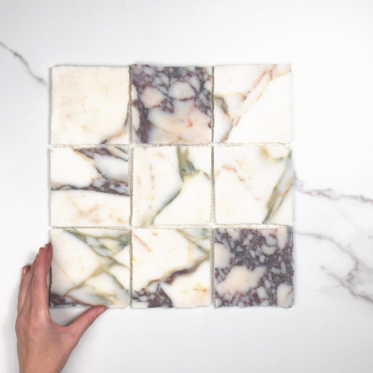 Elementa Calacatta Viola Mosaic 100x100mm top view, hand for scale