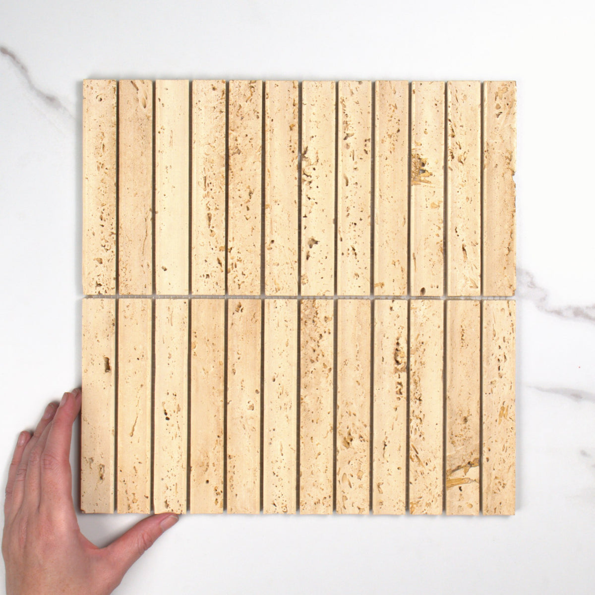 Elementa Travertine Ivory Concave Mosaic 23x148mm top view, hand for scale