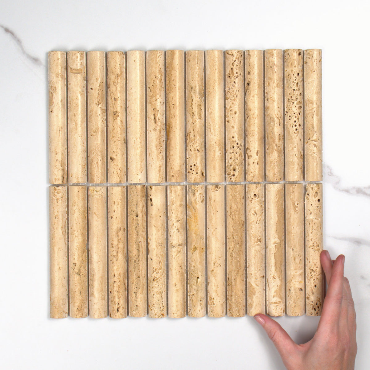 Elementa Travertine Ivory Fluted Mosaic 20x148mm top view, hand for scale