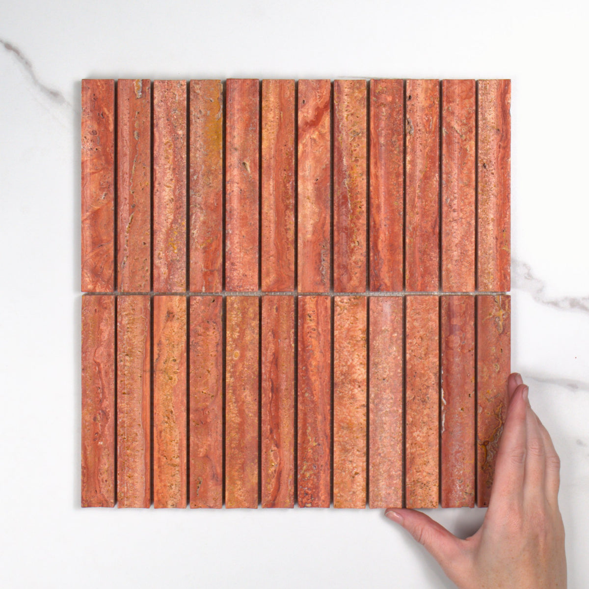 Elementa Travertine Red Concave Mosaic 23x148mm top view, hand for scale