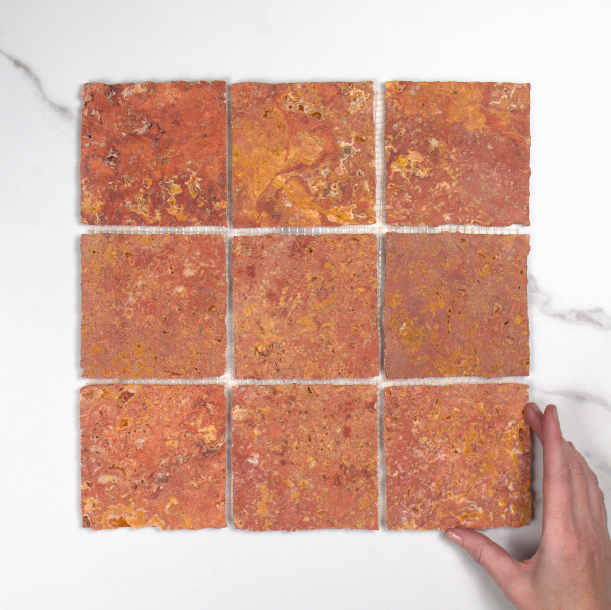 Elementa Travertine Red Mosaic 100x100mm top view, hand for scale