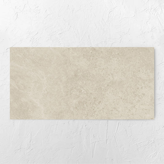 Executive Stone Marfil Honed 600x1200mm tile laid flat on a white rendered wall, showing the tile surface