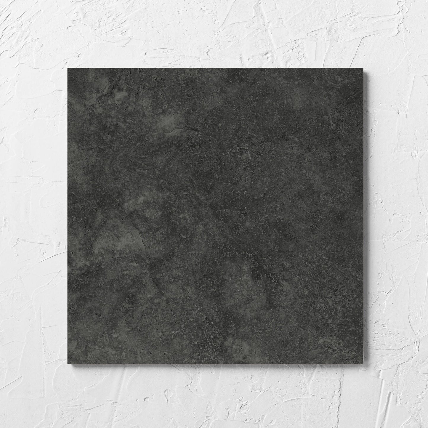 Fossil Stone Coal Matt 300x300mm tile laid flat on a white rendered wall, showing the matt surface