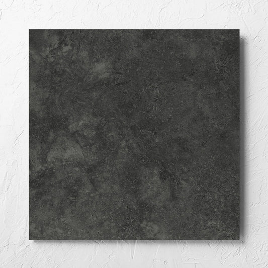 Fossil Stone Coal Matt 600x600mm tile laid flat on a white rendered wall, showing the matt surface