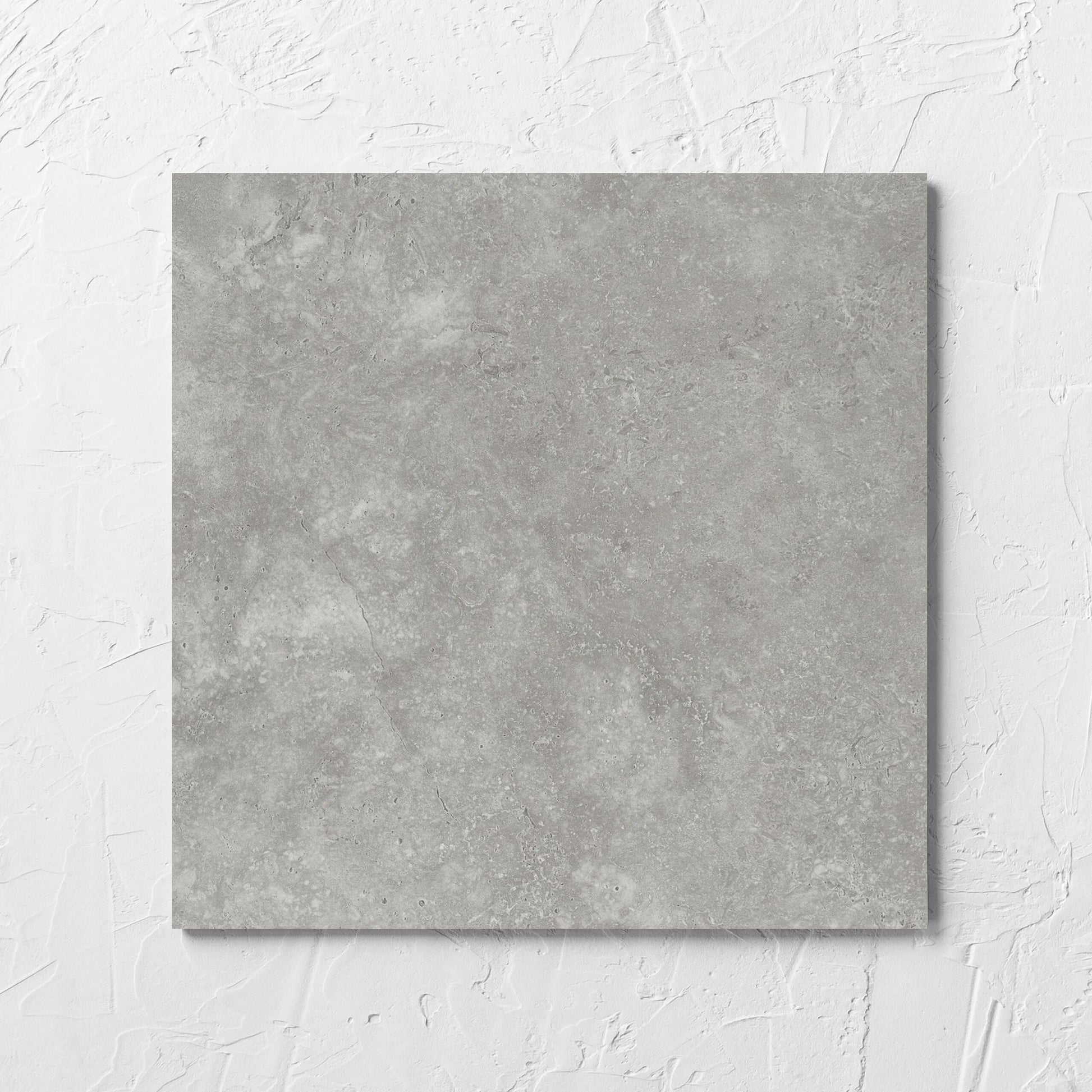 Fossil Stone Pebble Matt 300x300mm tile laid flat on a white rendered wall, showing the matt surface