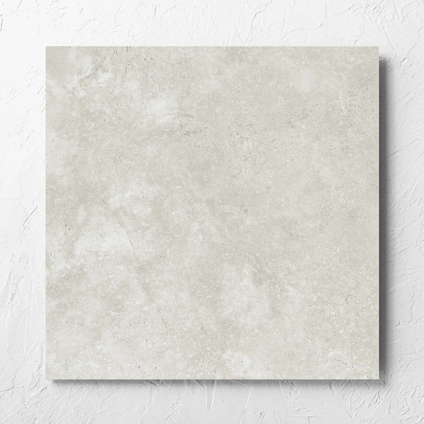 Fossil Stone Sand Matt 600x600mm tile laid flat on a white rendered wall, showing the matt surface