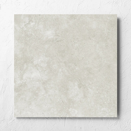 Fossil Stone Sand Matt 600x600mm tile laid flat on a white rendered wall, showing the matt surface