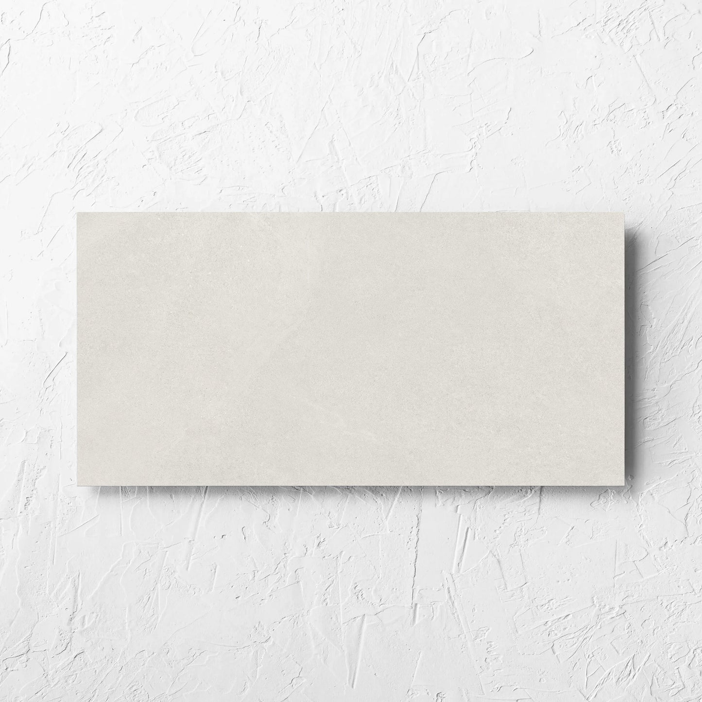 Fusion Bianco Ultra Tech 300x600mm tile laid flat on a white rendered wall, showing the matt surface