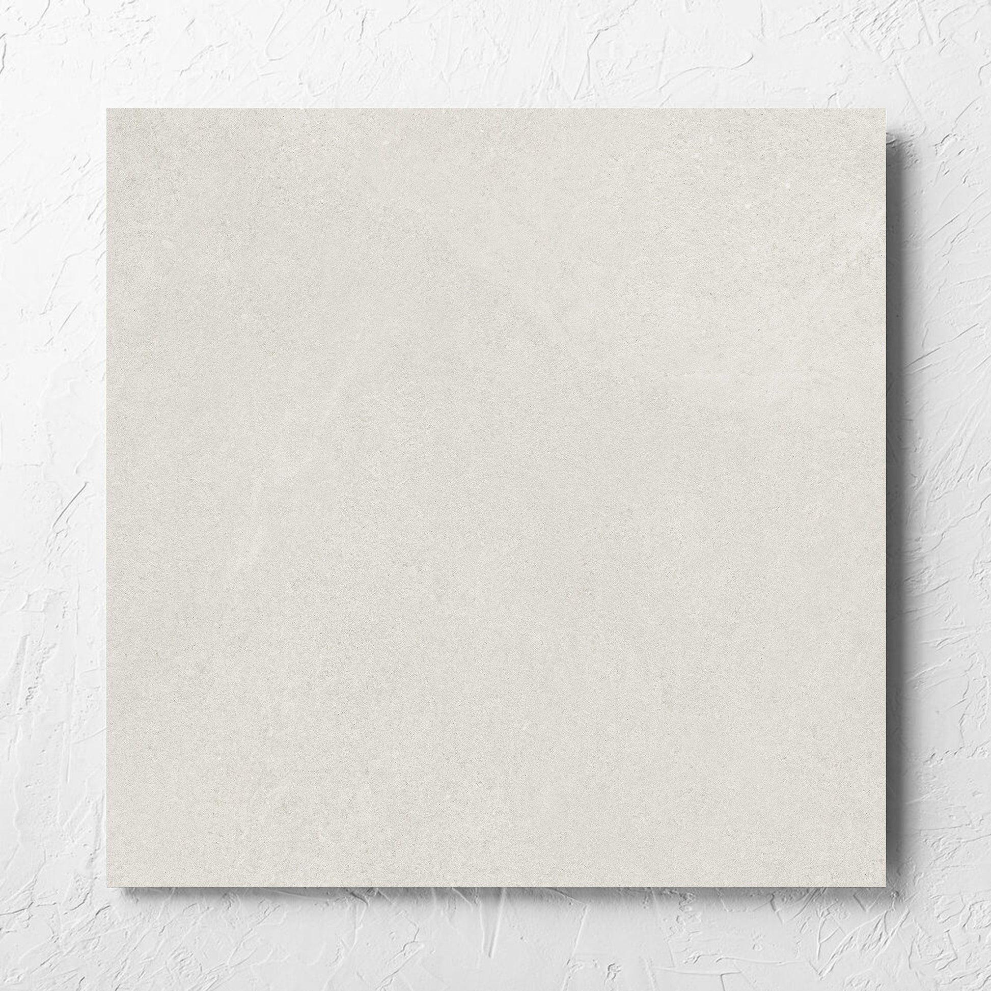 Fusion Bianco Ultra Tech 600x600mm tile laid flat on a white rendered wall, showing the matt surface