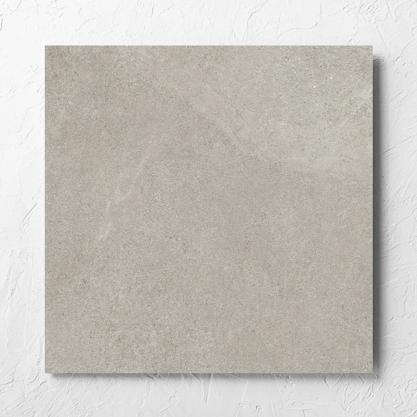 Fusion Cenere Ultra Tech 600x600mm tile laid flat on a white rendered wall, showing the matt surface