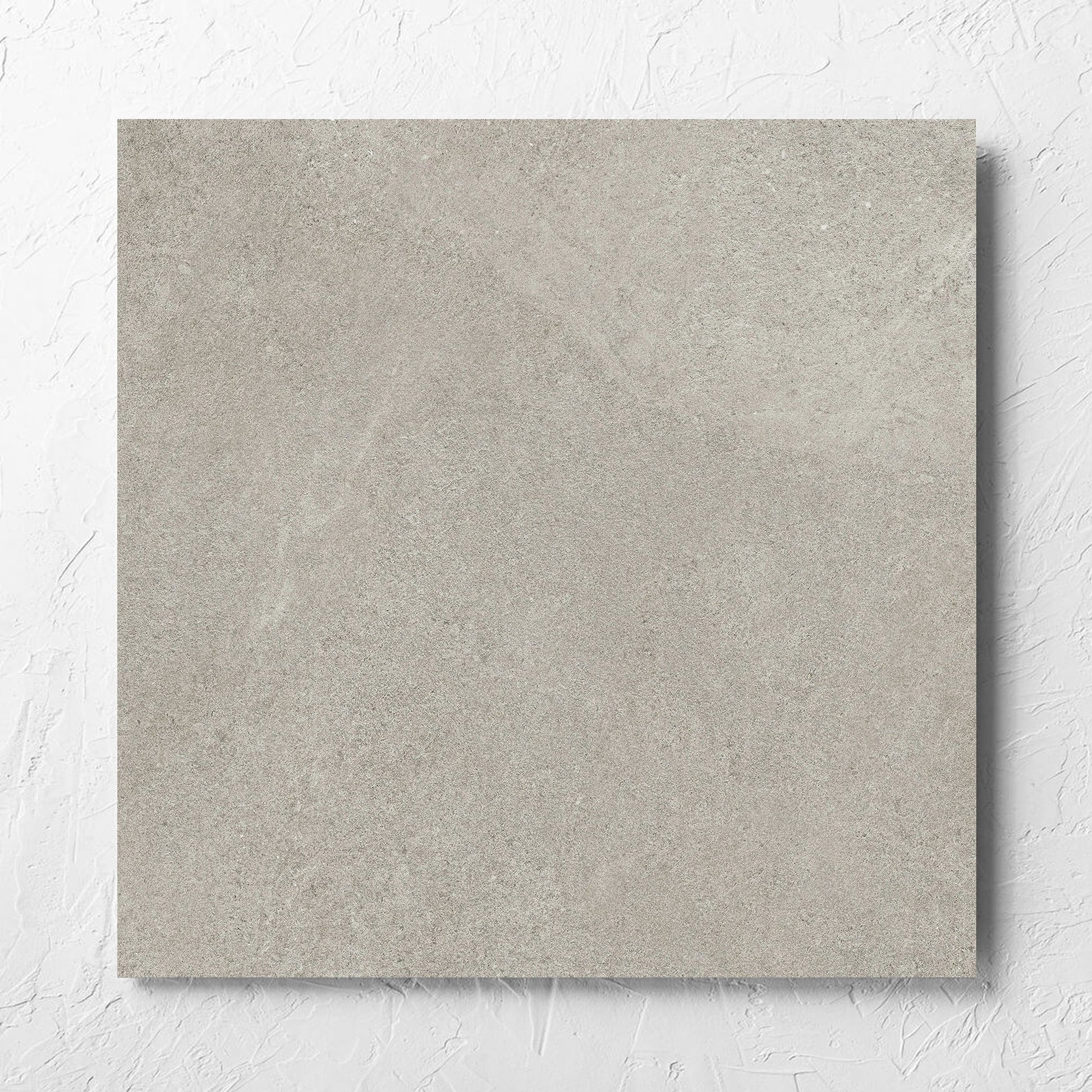 Fusion Cenere Ultra Tech 600x600mm tile laid flat on a white rendered wall, showing the matt surface