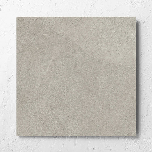 Fusion Cenere Ultra Tech 600x600mm tile laid flat on a white rendered wall, showing the matt surface