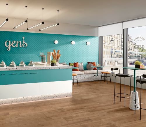 Genesis Shell Marine Blue 350x1000mm tiles installed as a vibrant teal feature wall in a stylish ice cream parlour with terrazzo counter and timber flooring.