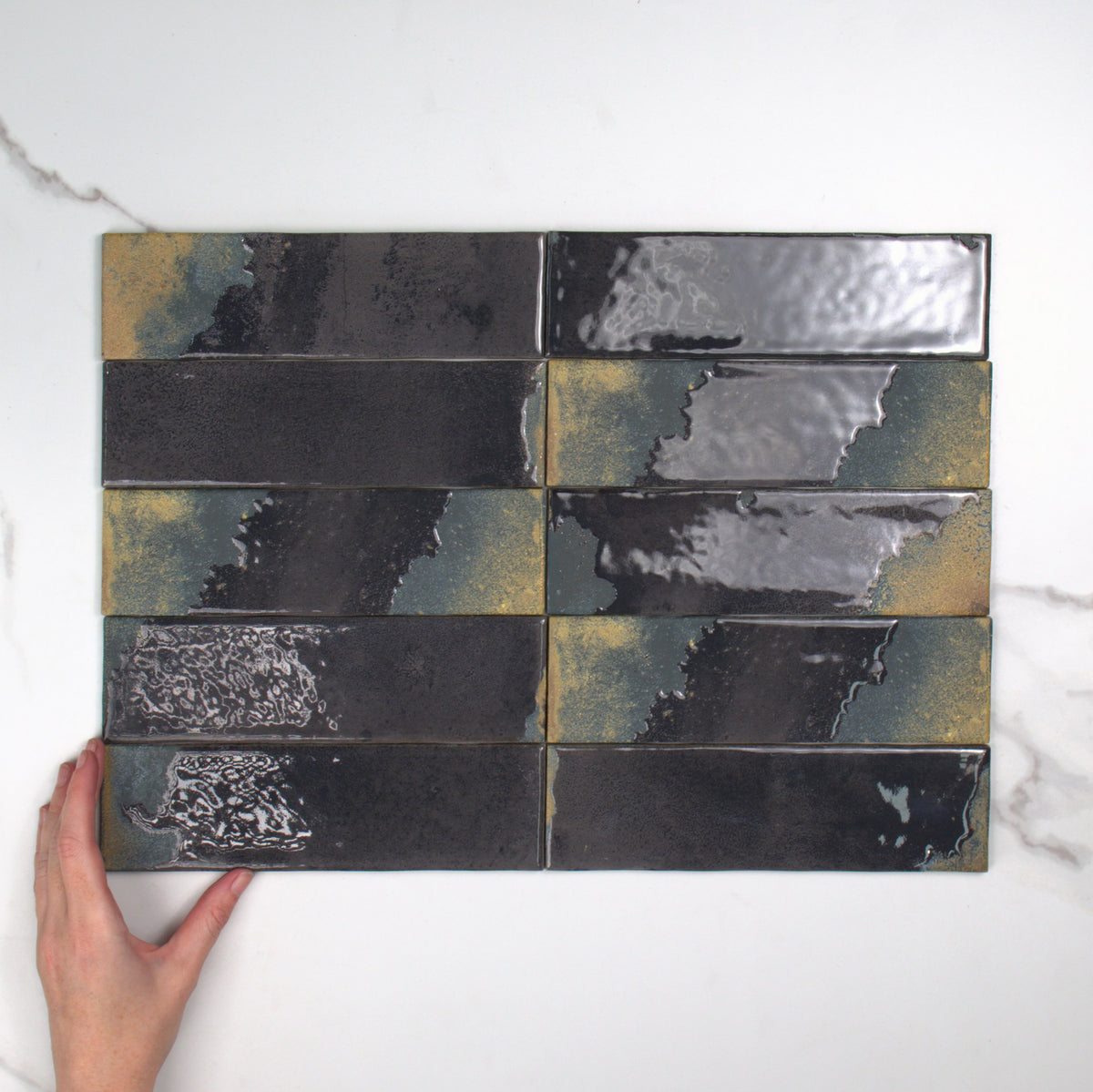 Granadella Carbon Gloss 64x223mm top view, hand for scale