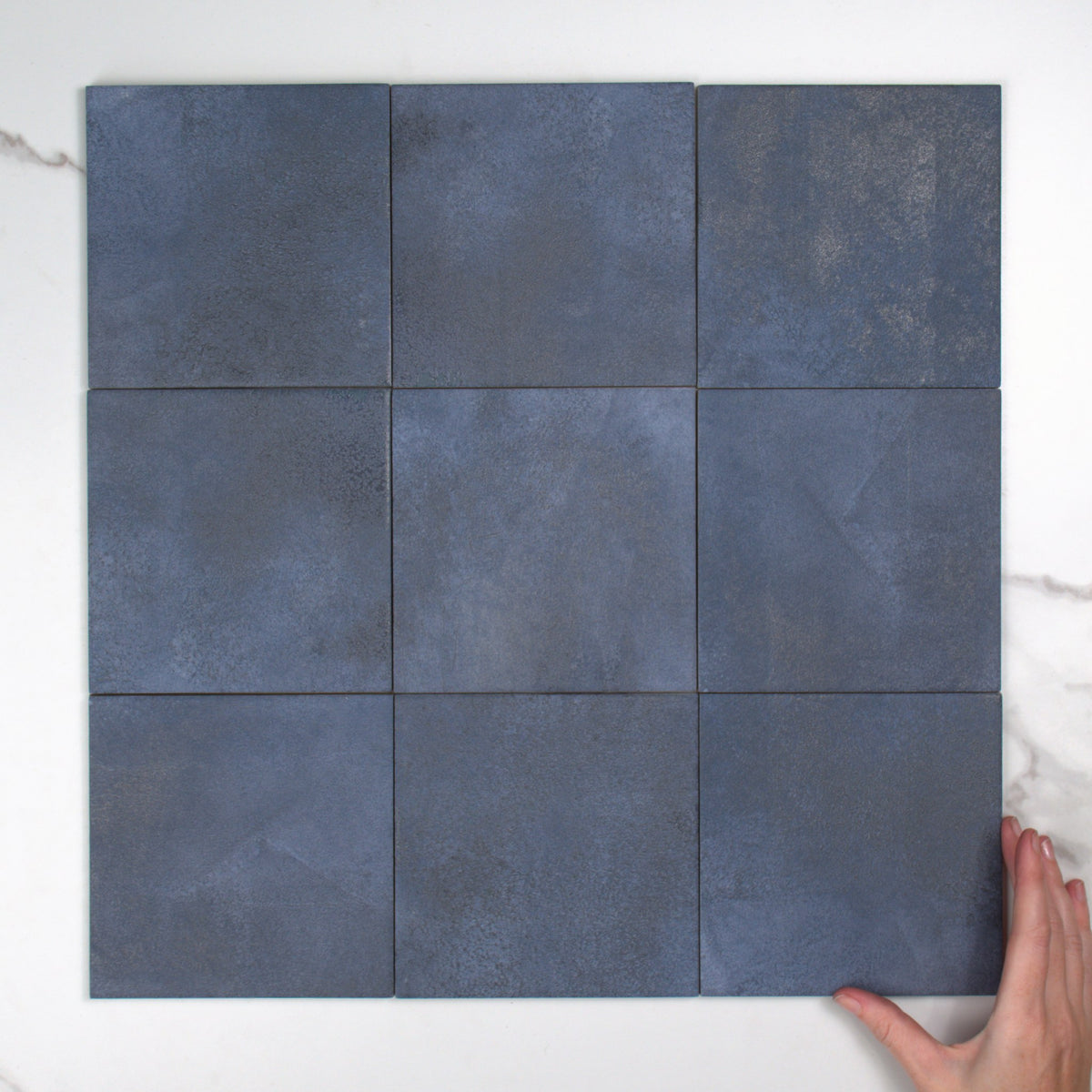 Greenland Cobalt Anti-Slip 147x147mm top view, hand for scale