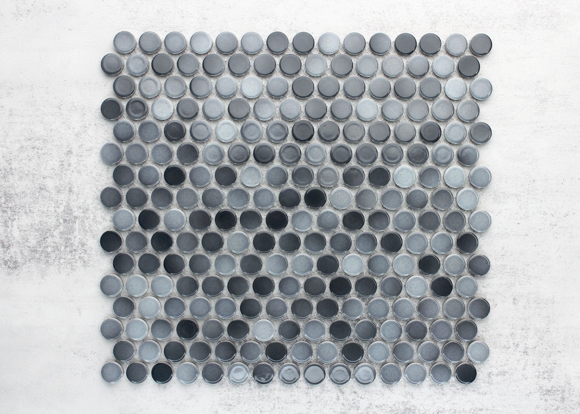 A flat lay pack shot of Grey Gloss Diameter Glazed Porcelain Penny Round 19mm tiles arranged in a mosaic sheet, showcasing mixed dark and light grey glazed circular coins on a white background.