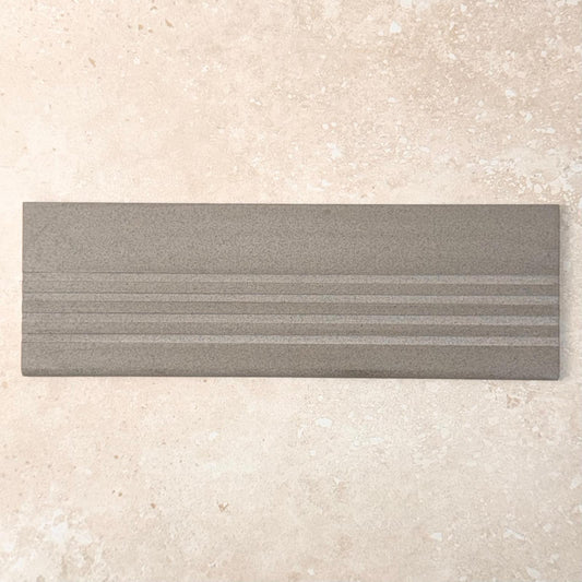 Grey Step Tread 60x300mm tile shown as a pack shot, featuring a matte grey finish with three raised parallel ribbed lines for slip resistance.