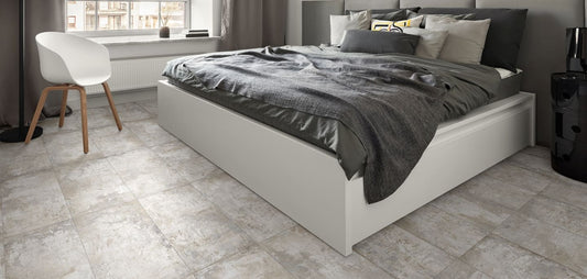 Grunge Beige Rectified 600x600mm porcelain floor tiles installed in a modern bedroom with a white platform bed and contemporary chair.