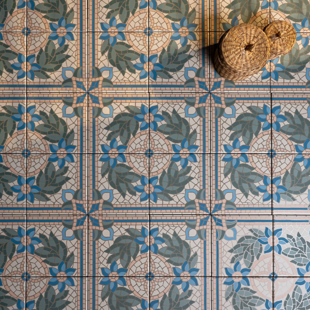 Highbury Ariadna 147x147mm decorative mosaic floor tiles with blue floral and green leaf pattern, styled with a wicker basket accessory.