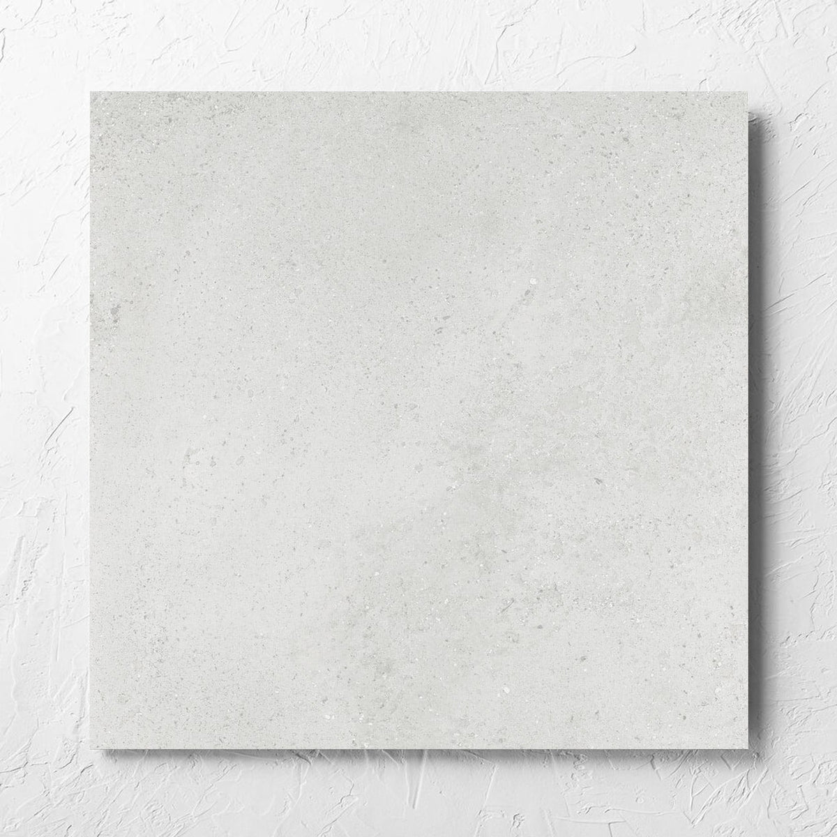 Imperial Light Grey Matt 600x600mm tile laid flat on a white rendered wall, showing the tile surface