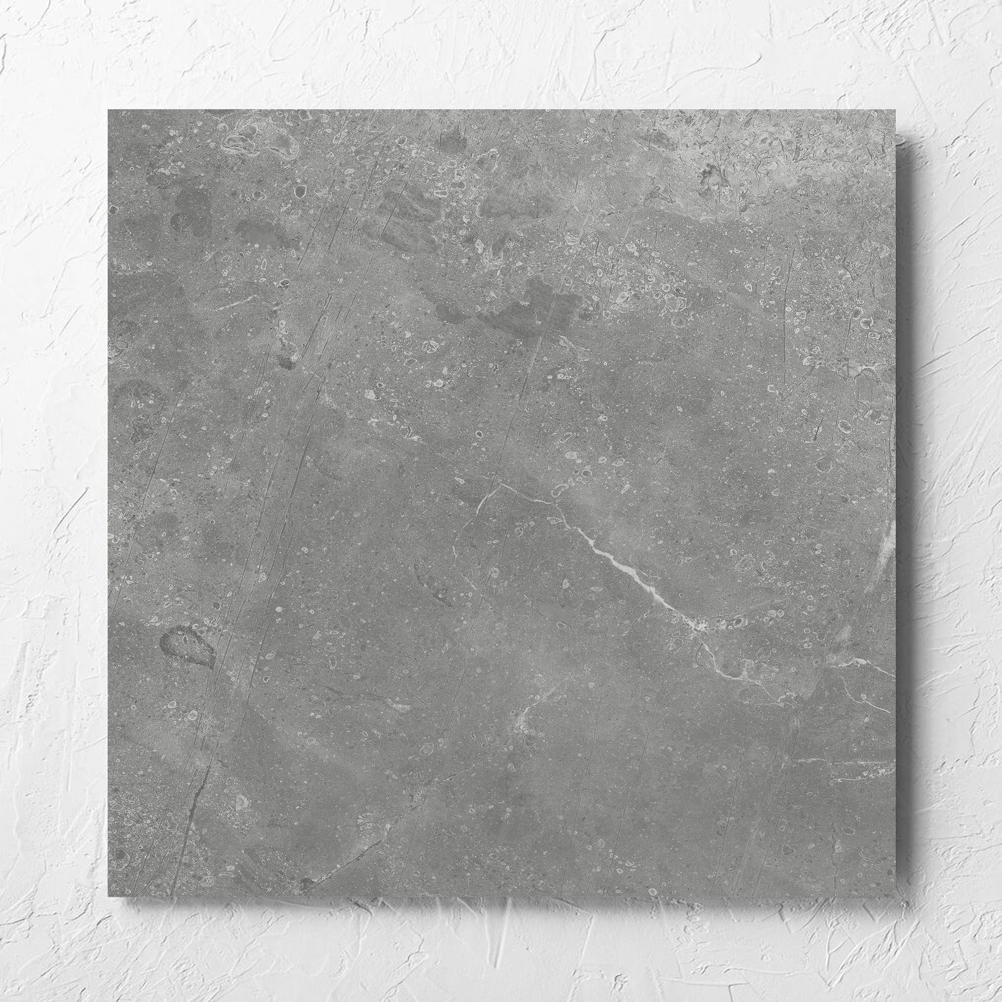 Kashmir Ash Matt 600x600mm tile laid flat on a white rendered wall, showing the matt surface