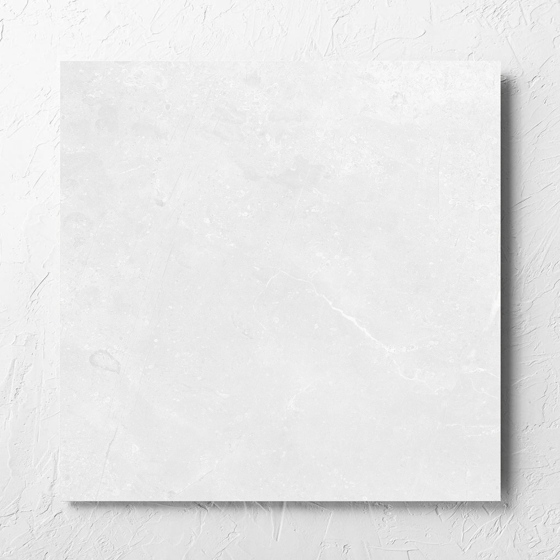 Kashmir Bone Matt 600x600mm tile laid flat on a white rendered wall, showing the matt surface