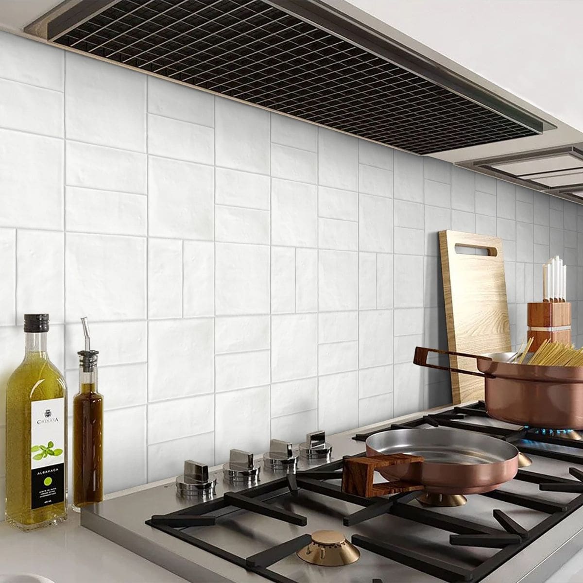 Krema Bar Cotton Gloss Krema Bar Cotton Gloss 62.5x125 white gloss tiles installed as a kitchen splashback behind a gas hob with copper cookware and cutting board.